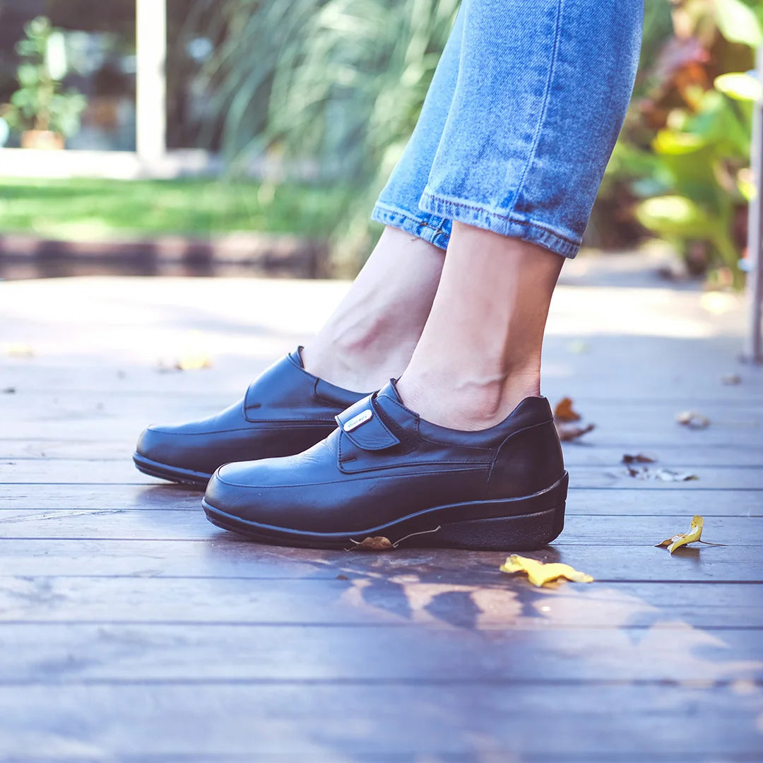 Woman in casual outfit wearing TDO wide fit rocker sole shoes for everyday foot support.